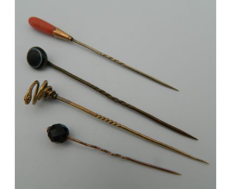 Four boxed stick pins, including gold examples