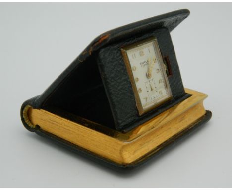 A mid 20th century  travelling clock in the form of a book, green leather, Made in USA. 6 cm high.