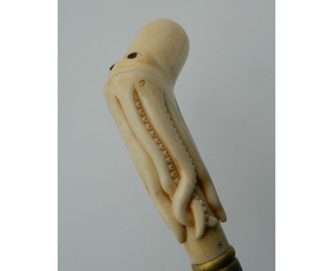 A bone carved walking stick formed as an octopus. 90 cm long.