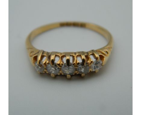An 18 ct gold five stone diamond ring. Ring size M