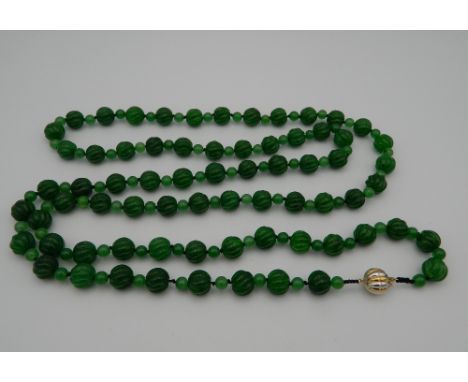 An apple green jade necklace, set with a bi-coloured 18 K gold clasp. 140 cm long.