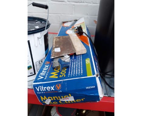 A tile cutter, grout and tools 