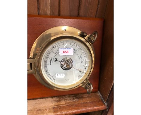 A Barometer mounted on a wooden base 