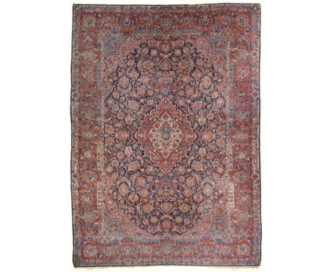 Good Kashan Carpet Central Iran the indigo field of floral vines around a cusped madder and ivory pole medallion framed by sa