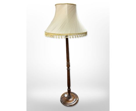 A turned beech standard lamp with tasseled shade 