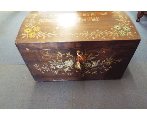 An early 20thC domed top shipping trunk with inset tray having floral decoration with German inscription