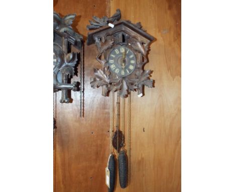 A Black Forest cuckoo clock having applied leaf and bird decoration