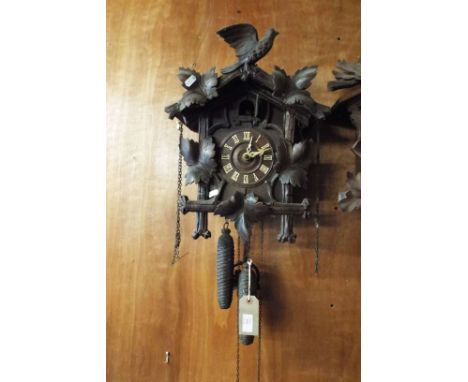 A Black Forest cuckoo clock having applied leaf and bird decoration