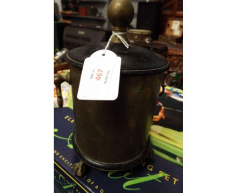 A late 19thC early 20thC cylindrical brass casket with ebonised lid and finial, drop ring handles and raised on claw and ball