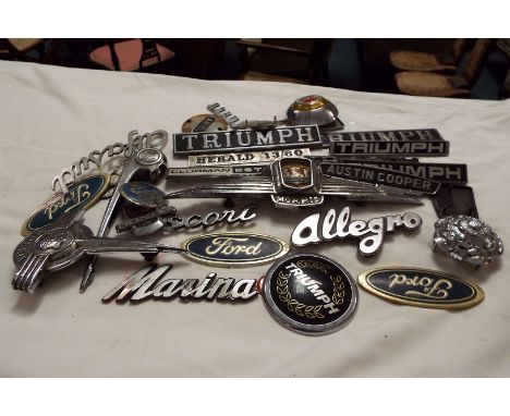 A large selection of car badges to include Mini Clubman, Allegro, Triumph, Morris, Leyland, Austin Copper etc