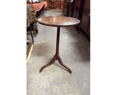 A George III circular oak wine table raised on a tapering support and tripod feet  