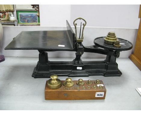 A Graduated Set of Brass Weights, in a wooden block; together with cast iron shop scales and weights.