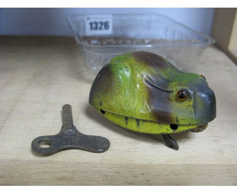 A Chad Valley Tin Plate Frog, having glass eyes, with key wind mechanism, legs to wheels, with key 4.5cm high.
