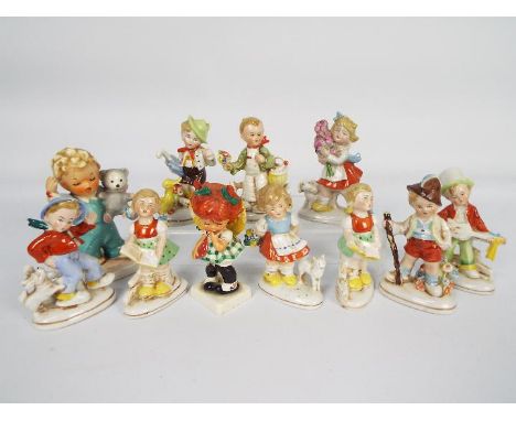 A collection of Hummel style figures and two Goebel Charlot Byj figures, largest approximately 13 cm (h).