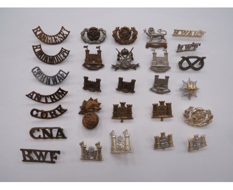 Selection of Titles and Collar Badges brass titles include Cork ... Antrim ... R Anglesey ... R Monmouth ... R.W.F. ... CNA. 