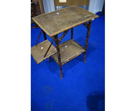 A vintage bamboo table with fold down shelf to side, height approx 70cm