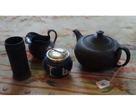 A Wedgwood Jasperware black basalt teapot and milk jug, together with a black basalt spill vase and an Adams Pottery covered 