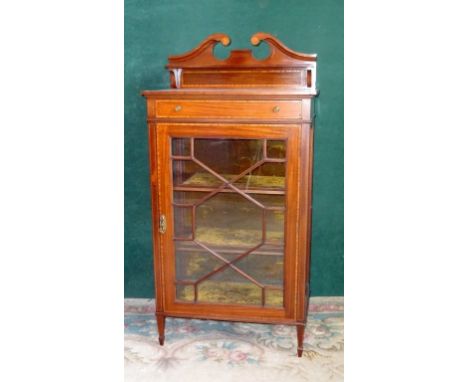 An Edwardian display cabinet, having broken scroll pediment over narrow shelf above a single door and astragally glazed door 