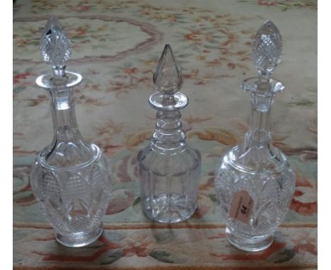A pair of crystal glass tall decanters (35cm), together with a smaller clear glass decanter of lobed form.