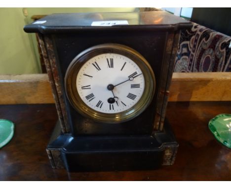 A small Victorian slate mantle clock, the enamel dial bearing Roman numerals.