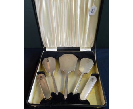 An early 20th century five piece cased dressing table set, comprising: silver backed brushes and a mirror, each with engine t