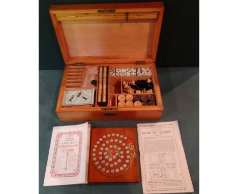An early 20th century boxed games compendium, to include: dominoes, chess, draughts, cribbage, Bezique and others. Condition 