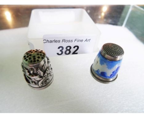 Two Continental silver thimbles, one having Delft-style enamel decoration of a Windmill in landscape, the other with winged c