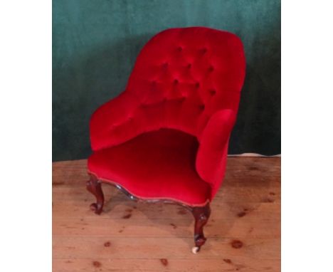 A Victorian red upholstered button back fireside chair on cabriole supports (68cm wide). Condition Report: 38cms seat height.