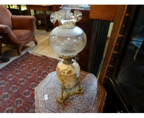 A Victorian oil lamp in the Aesthetic manner, the etched glass globe with a ceramic body on a tripod base (60cms)..
