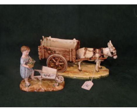 Two Continental ceramic figure groups, one of a donkey pulling a cart and the other of a young child with a wheelbarrow (the 