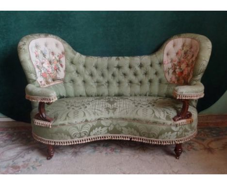 A Victorian green upholstered button back courting settee, having embroidered foliate panel to each end (178cm).