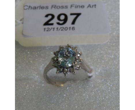 An aquamarine and diamond cluster ring, the faceted oval aquamarine claw mounted within a border of single cut diamonds to an