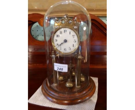 A brass torsion clock under dome, the enamel dial bearing Arabic numerals (17cm tall to include dome).