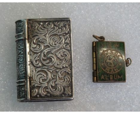 A white metal snuff box, modelled as a book, together with a miniature gilt metal and enamel pendant and charm modelled as a 