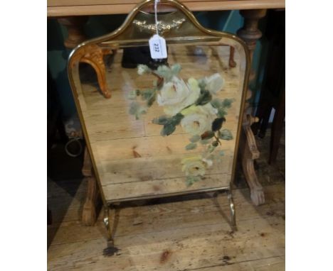 A brass framed fire screen, the central glass panel with hand painted floral decoration.