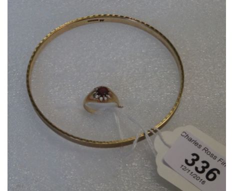A 9 carat gold bangle, together with a 9 carat gold ruby set ring, 25,7 grams.