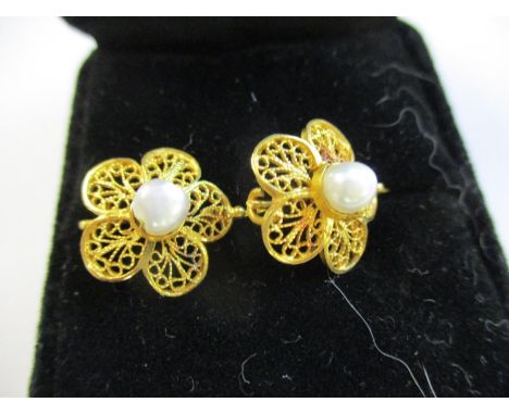 A pair of yellow metal flower earrings with central pearl 
