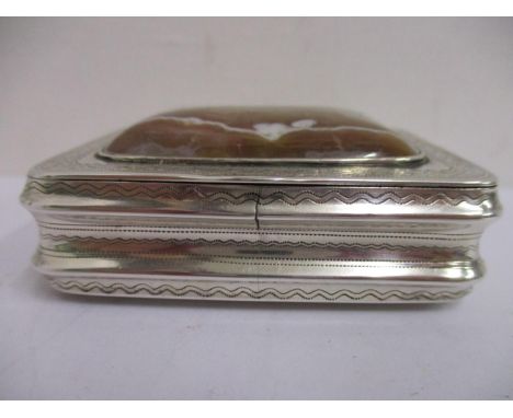 A silver coloured and gilt snuff box of rectangular form having fine engraving, the hinged lid inset with domed agate panel, 