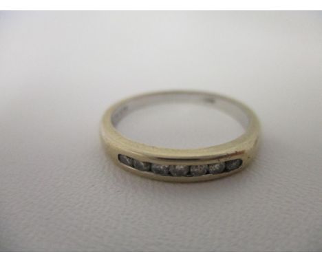 An 18ct white gold eternity style ring set with seven diamonds in a channel setting, total weight 2.30g 