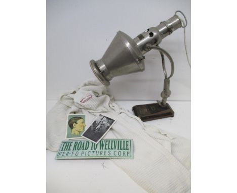 on a black painted metal base with a brass plaque converted to a lamp. The lamp was used on the film 'The Road to Wellville' 