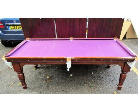 A Victorian walnut slate bed billiards/dining table with three removable leaves revealing a purple baize and cushions, on two