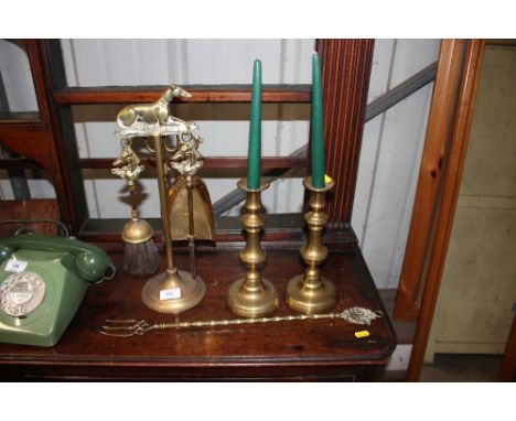 A pair of brass candlesticks; a brass companion set; and toasting fork