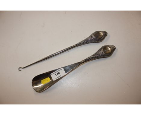 A silver handled button hook and shoe horn