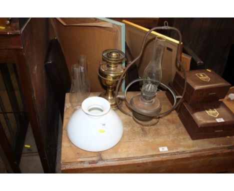 A brass oil lamp; and a hanging brass oil lamp with milk glass shade 