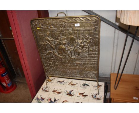 A large brass embossed fire screen