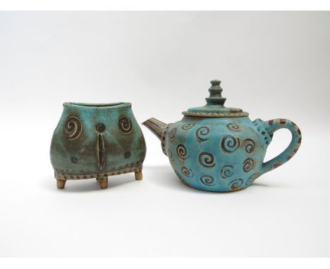 A Studio pottery teapot, turquoise glaze with spiral motifs (chip to spout) and amatching ppot raised on four legs, glazed ov