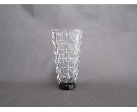 An Orrefors clear glass vase, stepped facet cut sides on black glass foot, designed by Simon Gate, etched marks to base. 23cm