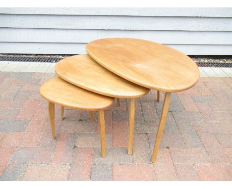 A modern nest of 'pebble' type tables in the style of Ercol, raised on rectangular legs 