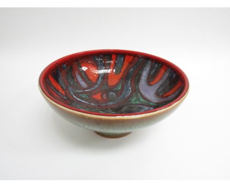 A Poole Pottery Delphis pedestal bowl, green glazed exterior, interior with red, green and black design. Printed and painted 