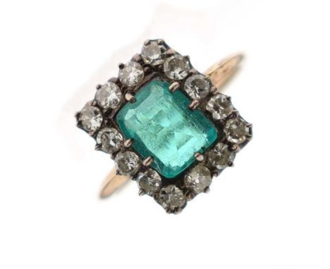 Early 20th century emerald and diamond cluster ring, the rectangular step cut emerald measuring approx 8.22mm x 6.82mm x 3.51